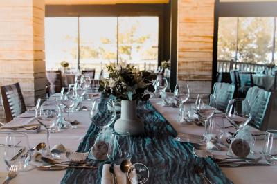 Salle de bain moderne avec meuble en bois clair, lavabo, miroir et douche vitrée équipée d'une pomme de douche.