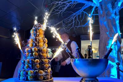 Salle de bain moderne avec meuble en bois clair, lavabo, miroir et douche vitrée équipée d'une pomme de douche.