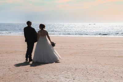 Salle de bain moderne avec meuble en bois clair, lavabo, miroir et douche vitrée équipée d'une pomme de douche.
