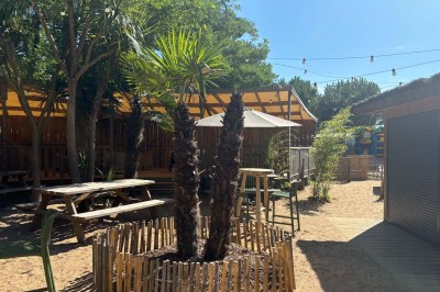 Salle de bain moderne avec meuble en bois clair, lavabo, miroir et douche vitrée équipée d'une pomme de douche.