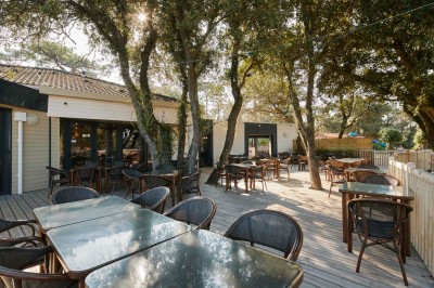 Salle de bain moderne avec meuble en bois clair, lavabo, miroir et douche vitrée équipée d'une pomme de douche.