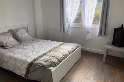 Chambre avec lits superposés, grandes fenêtres laissant entrer la lumière naturelle et parquet clair.