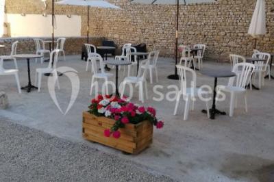 Décoration champêtre avec panneaux directionnels, fleurs, et accessoires pour un événement en extérieur.