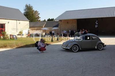 Décoration champêtre avec panneaux directionnels, fleurs, et accessoires pour un événement en extérieur.