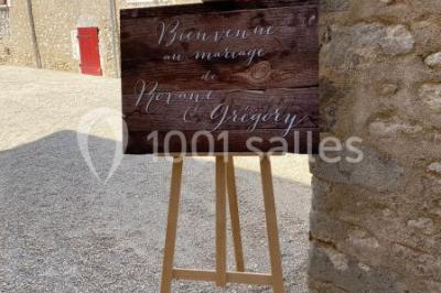 Décoration champêtre avec panneaux directionnels, fleurs, et accessoires pour un événement en extérieur.
