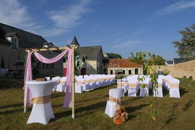 Décoration champêtre avec panneaux directionnels, fleurs, et accessoires pour un événement en extérieur.