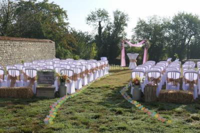 Décoration champêtre avec panneaux directionnels, fleurs, et accessoires pour un événement en extérieur.
