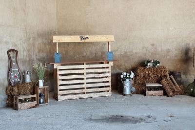 Décoration champêtre avec panneaux directionnels, fleurs, et accessoires pour un événement en extérieur.