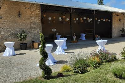 Décoration champêtre avec panneaux directionnels, fleurs, et accessoires pour un événement en extérieur.