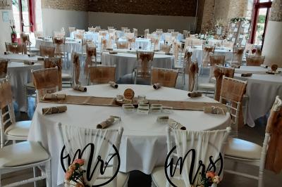 Décoration champêtre avec panneaux directionnels, fleurs, et accessoires pour un événement en extérieur.