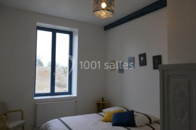 Un groupe de personnes sur scène lors d'une remise de prix dans une salle avec un mur en pierre et un écran de projection.