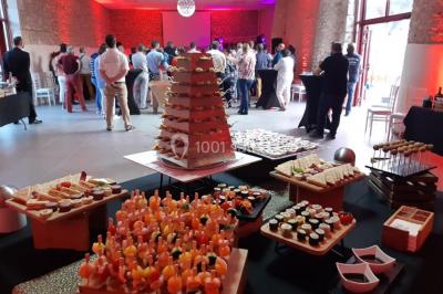 Un groupe de personnes sur scène lors d'une remise de prix dans une salle avec un mur en pierre et un écran de projection.