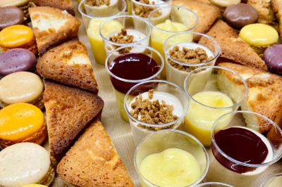 Plateau de buffet avec mini-sandwichs, verrines de salade, tartelettes salées et bouchées variées.