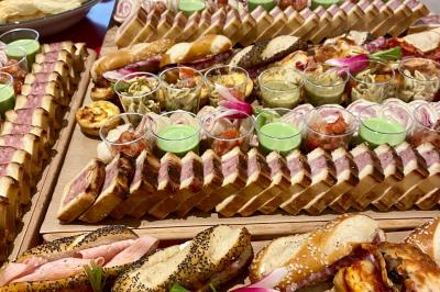 Plateau de buffet avec mini-sandwichs, verrines de salade, tartelettes salées et bouchées variées.