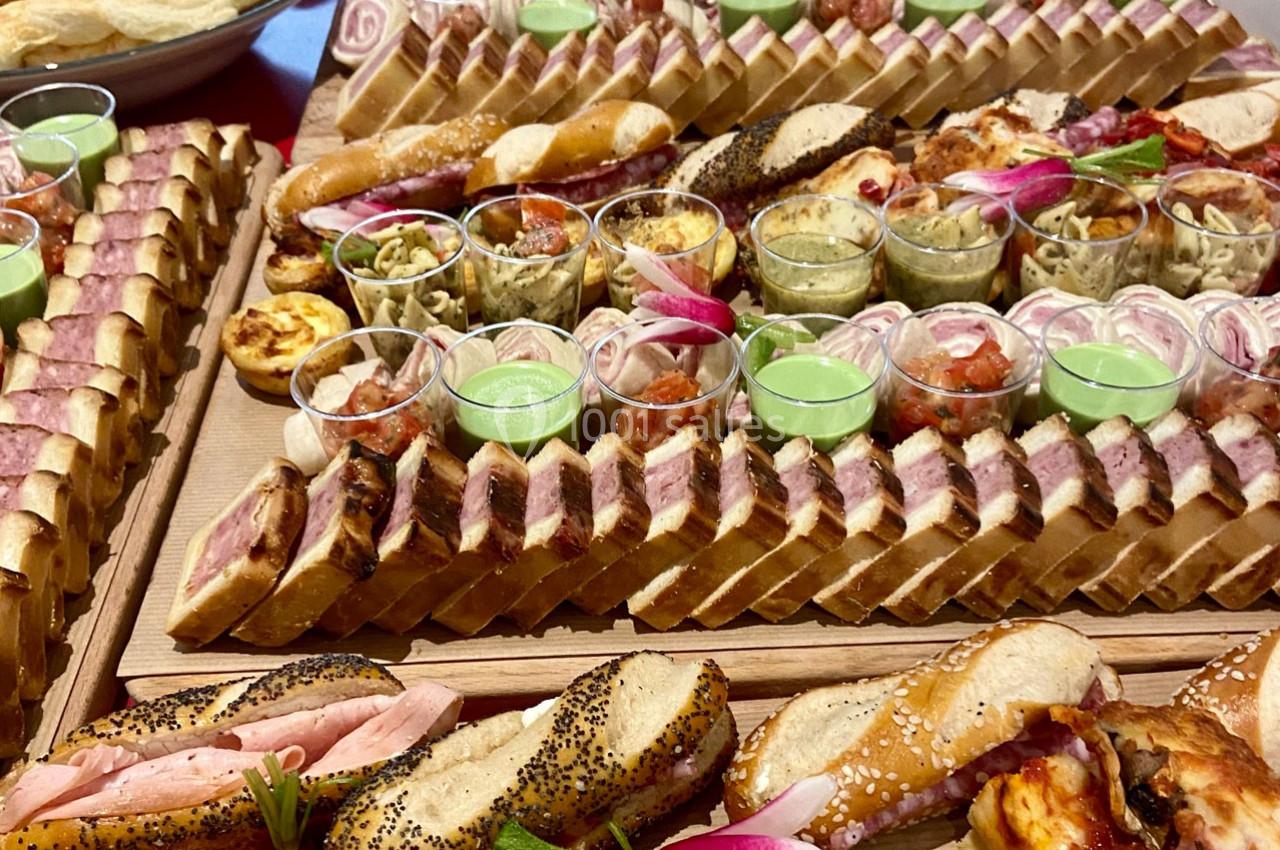 Plateau de buffet avec assortiments de sandwiches, verrines, quiches et garnitures variées.