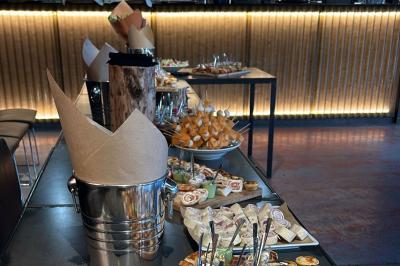 Plateau de buffet avec mini-sandwichs, verrines de salade, tartelettes salées et bouchées variées.