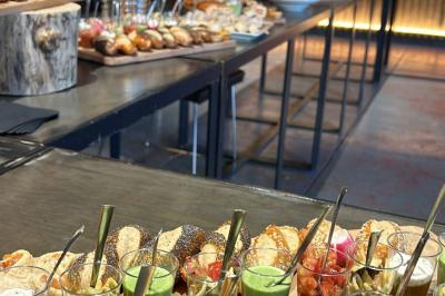 Plateau de buffet avec mini-sandwichs, verrines de salade, tartelettes salées et bouchées variées.
