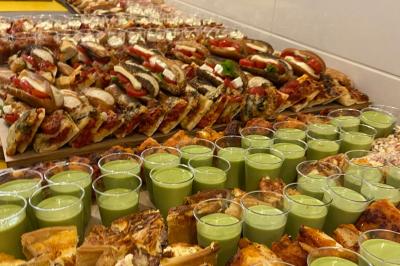 Plateau de buffet avec mini-sandwichs, verrines de salade, tartelettes salées et bouchées variées.