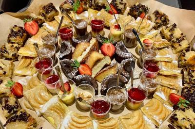 Plateau de buffet avec mini-sandwichs, verrines de salade, tartelettes salées et bouchées variées.