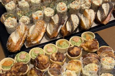 Plateau de buffet avec mini-sandwichs, verrines de salade, tartelettes salées et bouchées variées.