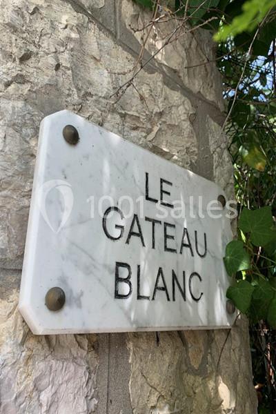 Plaque en marbre blanc fixée sur un mur en pierre, portant l'inscription ’Le Gâteau Blanc’.