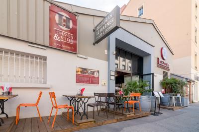 Salle de restaurant moderne avec tables noires, chaises rouges transparentes et décoration murale contemporaine.