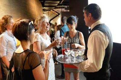 Verres de vin rouge et blanc sur un tonneau en bois, accompagnés de chocolats assortis disposés sur des tablettes.