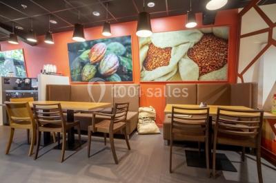 Verres de vin rouge et blanc sur un tonneau en bois, accompagnés de chocolats assortis disposés sur des tablettes.