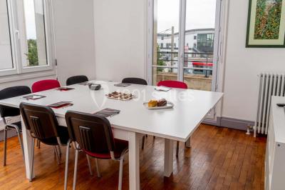 Verres de vin rouge et blanc sur un tonneau en bois, accompagnés de chocolats assortis disposés sur des tablettes.