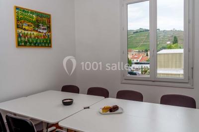Verres de vin rouge et blanc sur un tonneau en bois, accompagnés de chocolats assortis disposés sur des tablettes.