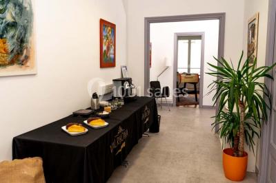 Verres de vin rouge et blanc sur un tonneau en bois, accompagnés de chocolats assortis disposés sur des tablettes.