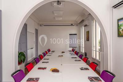 Verres de vin rouge et blanc sur un tonneau en bois, accompagnés de chocolats assortis disposés sur des tablettes.