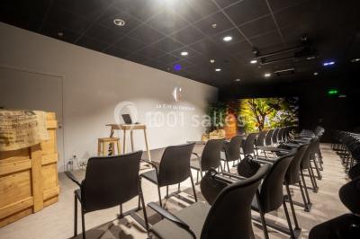 Verres de vin rouge et blanc sur un tonneau en bois, accompagnés de chocolats assortis disposés sur des tablettes.