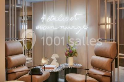 Salle à manger moderne avec grande table noire, chaises assorties, vaisselle dressée et décor mural en assiettes.