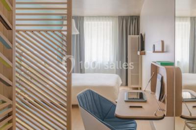 Salle à manger moderne avec grande table noire, chaises assorties, vaisselle dressée et décor mural en assiettes.