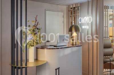 Salle à manger moderne avec grande table noire, chaises assorties, vaisselle dressée et décor mural en assiettes.