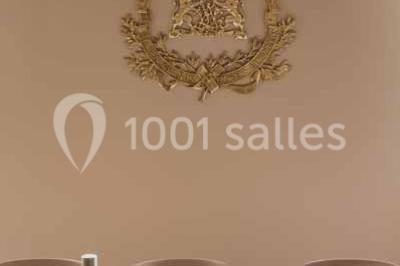 Salle à manger moderne avec grande table noire, chaises assorties, vaisselle dressée et décor mural en assiettes.