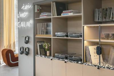 Salle à manger moderne avec grande table noire, chaises assorties, vaisselle dressée et décor mural en assiettes.