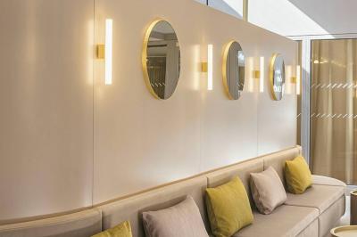 Salle à manger moderne avec grande table noire, chaises assorties, vaisselle dressée et décor mural en assiettes.