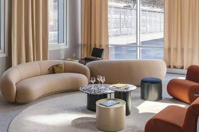 Salle à manger moderne avec grande table noire, chaises assorties, vaisselle dressée et décor mural en assiettes.