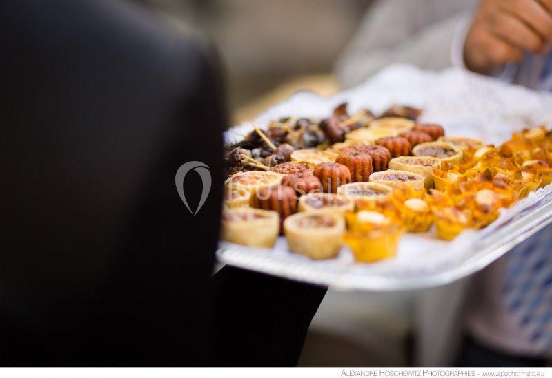 Plateau de mignardises variées comprenant tartelettes, bouchées sucrées et salées, présenté lors d'un événement.