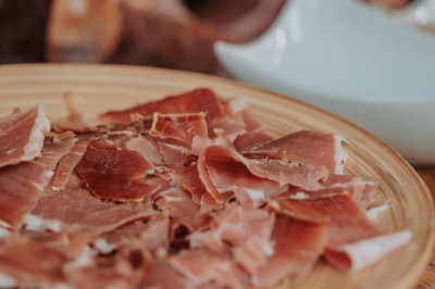 Plateau doré contenant des cuillères individuelles garnies de petites portions de nourriture raffinée.