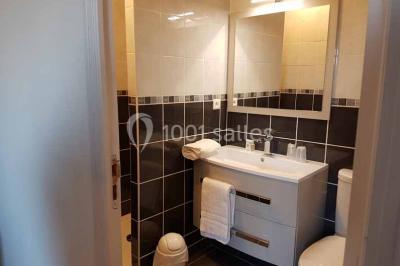 Arbres et arbustes couverts de givre dans un paysage rural sous un ciel bleu clair.