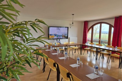 Salle de bain avec lavabo, miroir éclairé, serviettes pliées, poubelle et carrelage noir et blanc.