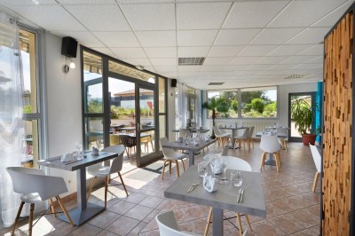 Salle de bain avec lavabo, miroir éclairé, serviettes pliées, poubelle et carrelage noir et blanc.