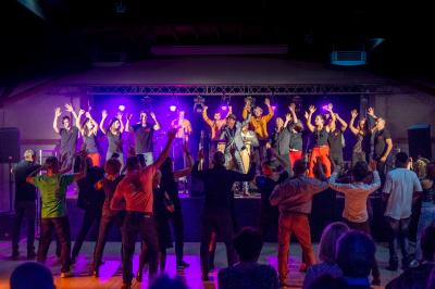 Vue aérienne d'un château médiéval entouré de verdure, au cœur d'une petite ville avec des habitations et des routes.