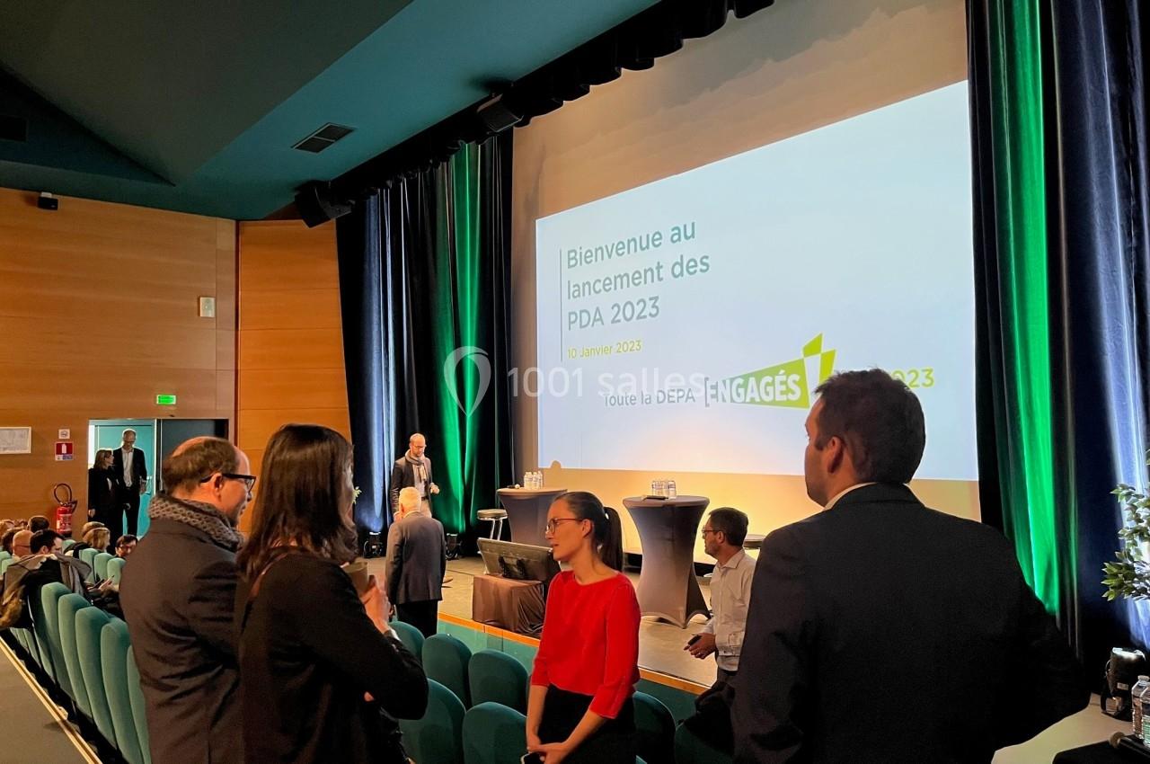 Des personnes discutent dans une salle de conférence avec un écran affichant ’Bienvenue au lancement des PDA 2023’.