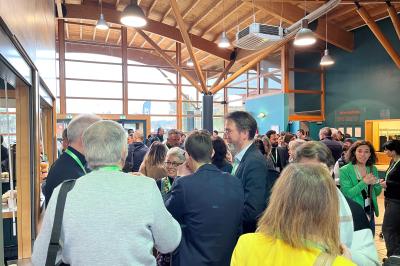 Vue aérienne d'un château médiéval entouré de verdure, au cœur d'une petite ville avec des habitations et des routes.