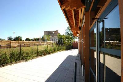 Vue aérienne d'un château médiéval entouré de verdure, au cœur d'une petite ville avec des habitations et des routes.