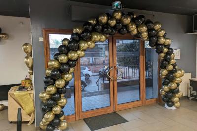 Salle spacieuse avec carrelage au sol, murs clairs, plafond noir, tables et chaises dispersées.